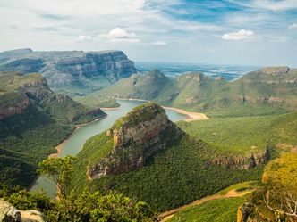 Which country is entirely surrounded by South Africa, is known for its mountainous terrain and the highest pub in Africa